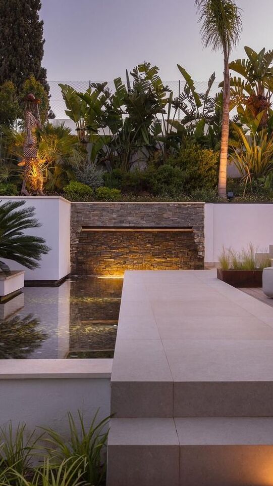 Vertical garden corner at Villa Aquila with stepped landscaping, warm evening lighting and planted retaining walls