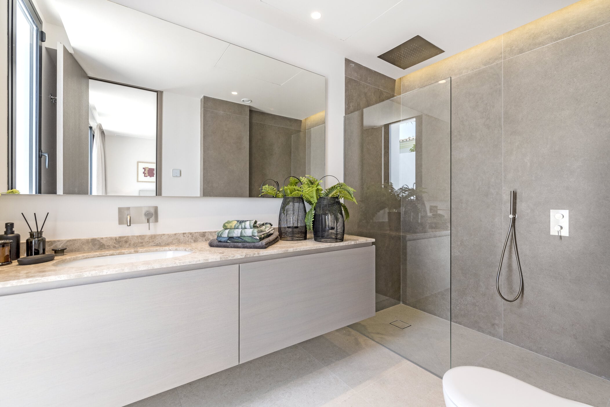 Refined bathroom interior at Villa Aquila with floating vanity, natural stone and integrated lighting