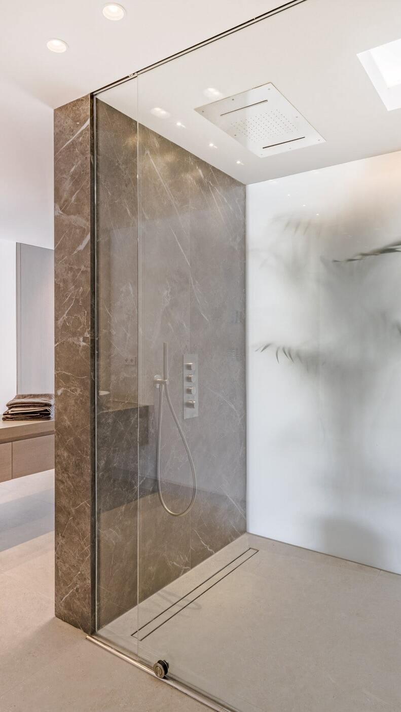 Vertical detail of the stone and glass shower enclosure in the main bathroom of Villa Aquila