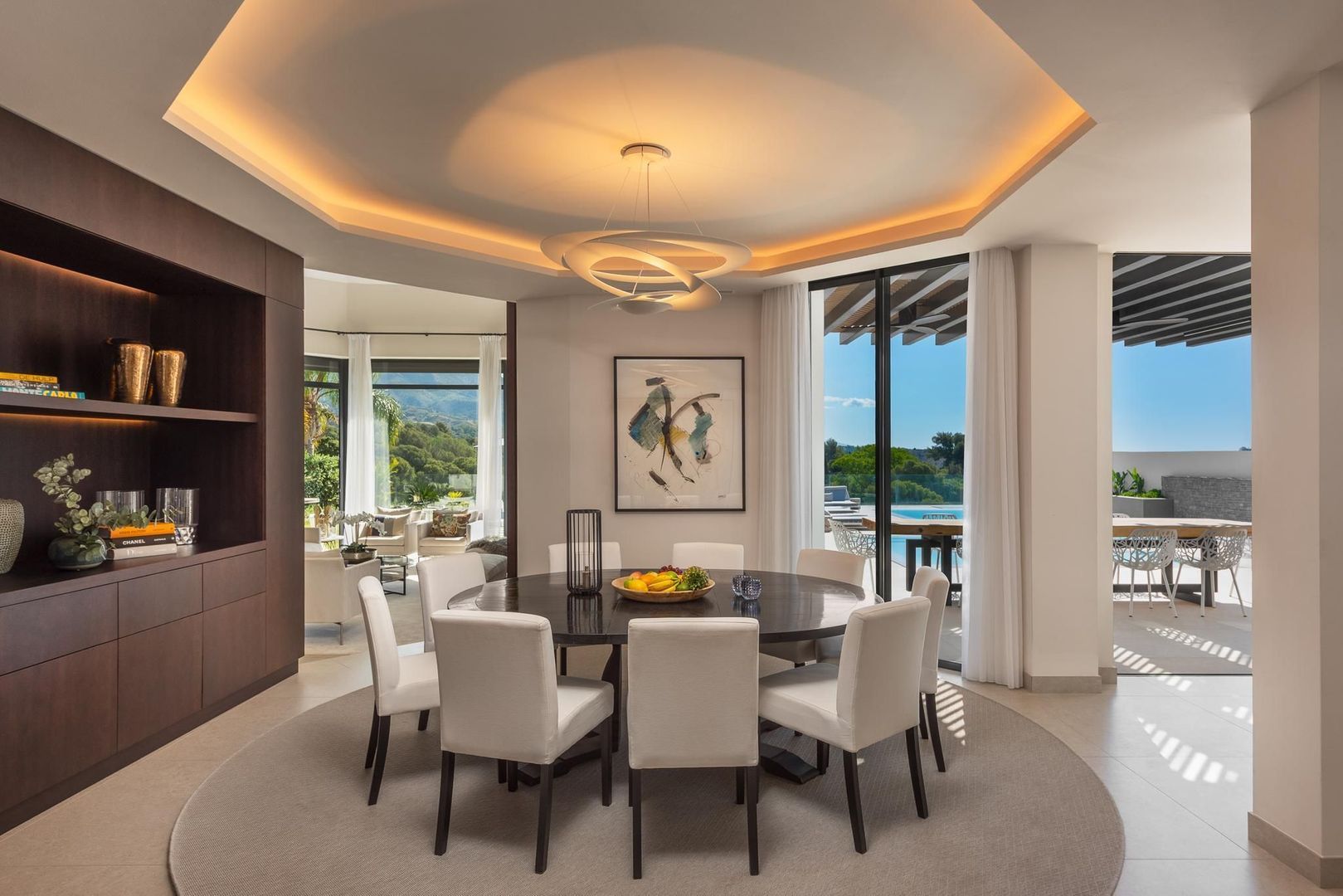 Dining room at Villa Aquila with sculptural ceiling, refined lighting and open plan relation to the terrace