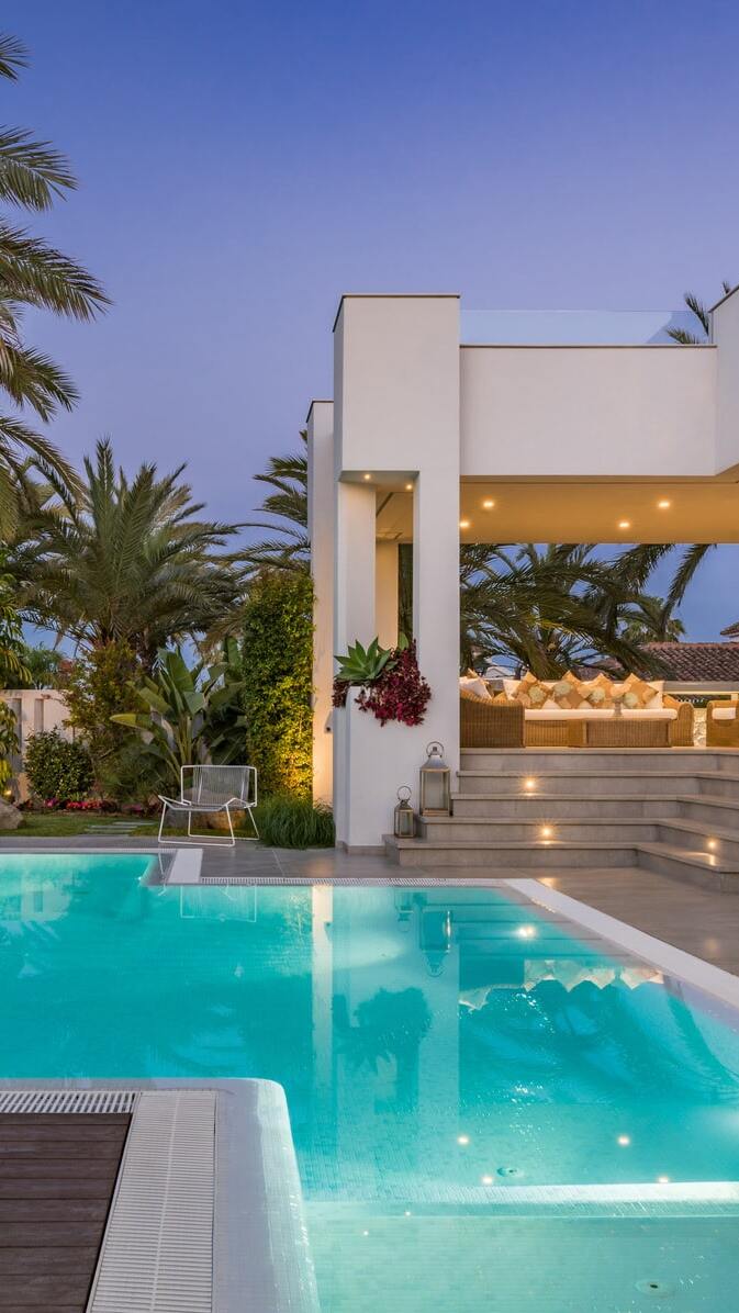 Vertical composition of the pool edge and terrace corner at Villa Australia during blue hour