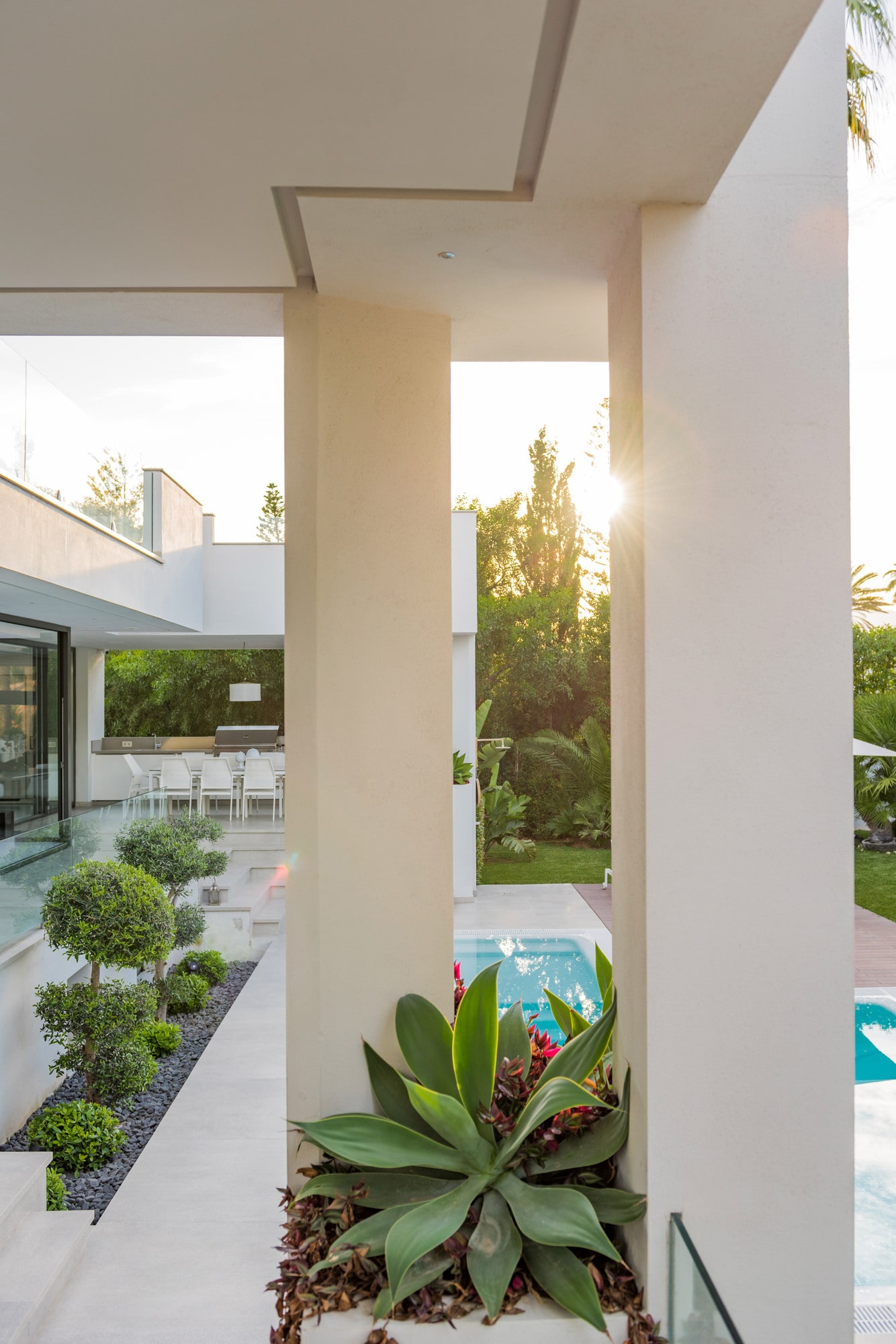 Covered terrace and planted edge at Villa Australia with sunset light filtering into the entrance porch