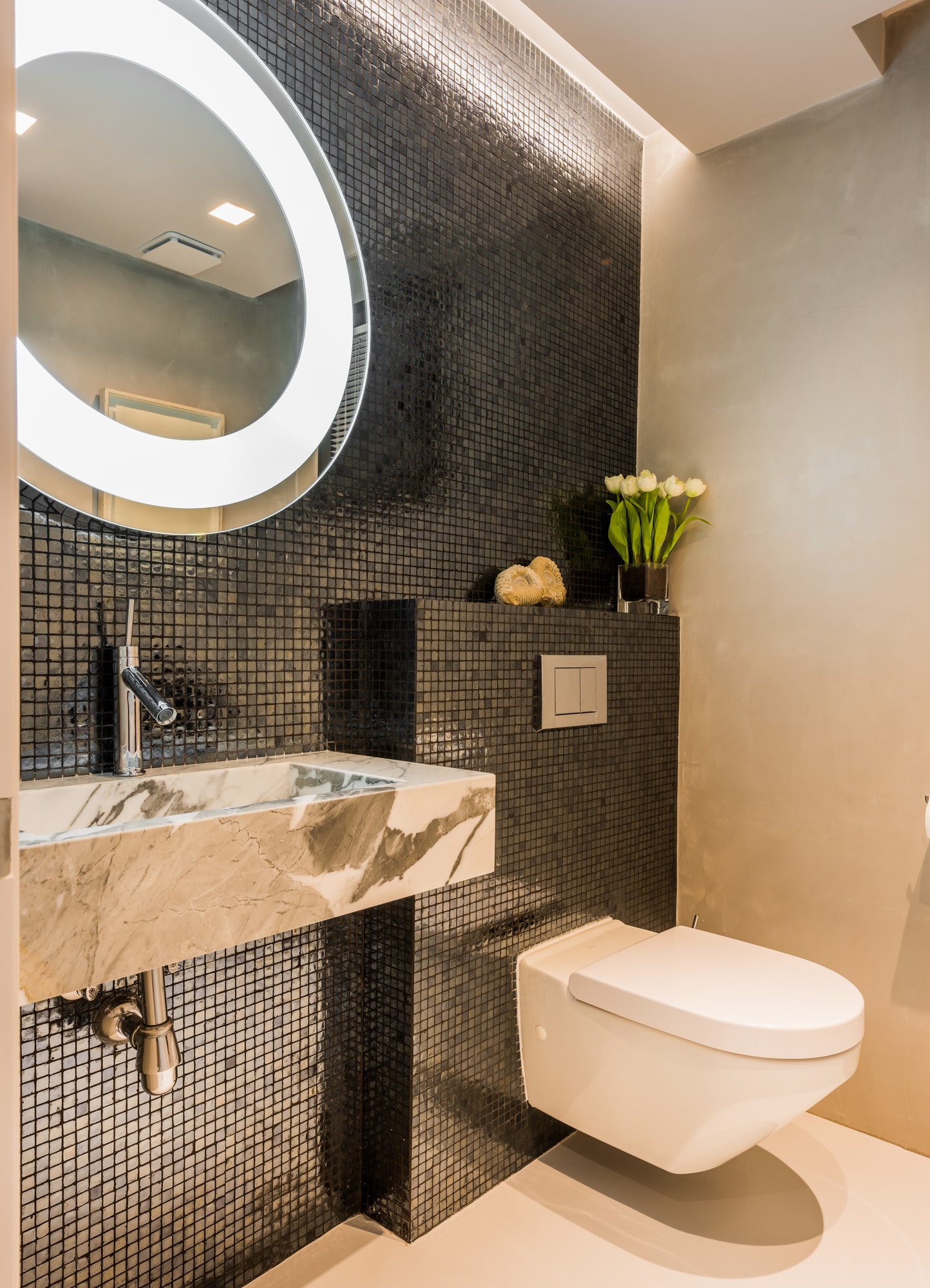 Secondary bathroom at Villa Australia with circular illuminated mirror, dark stone textures and restrained luxury detail
