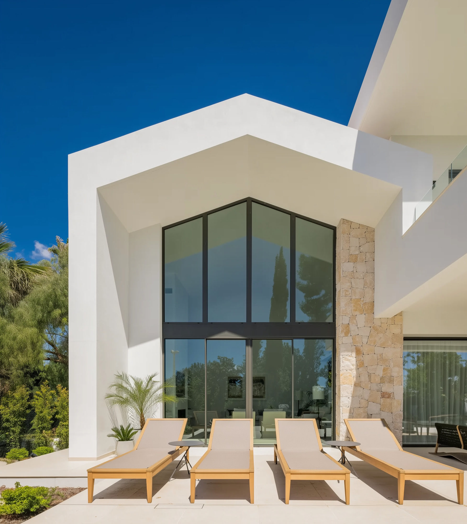 Double height entrance façade with large glazing and sculptural geometry