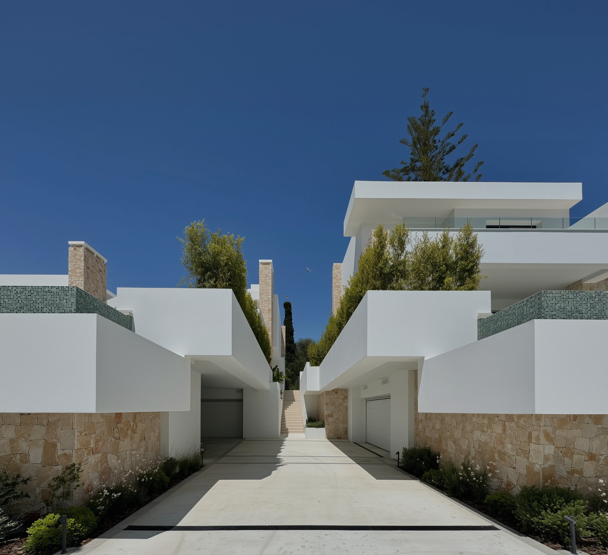 Architectural pathway framed by white walls and garden planting