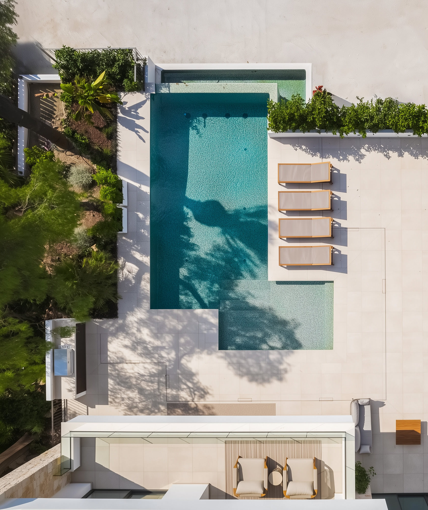 Aerial view of pool terrace and sun loungers within tropical garden