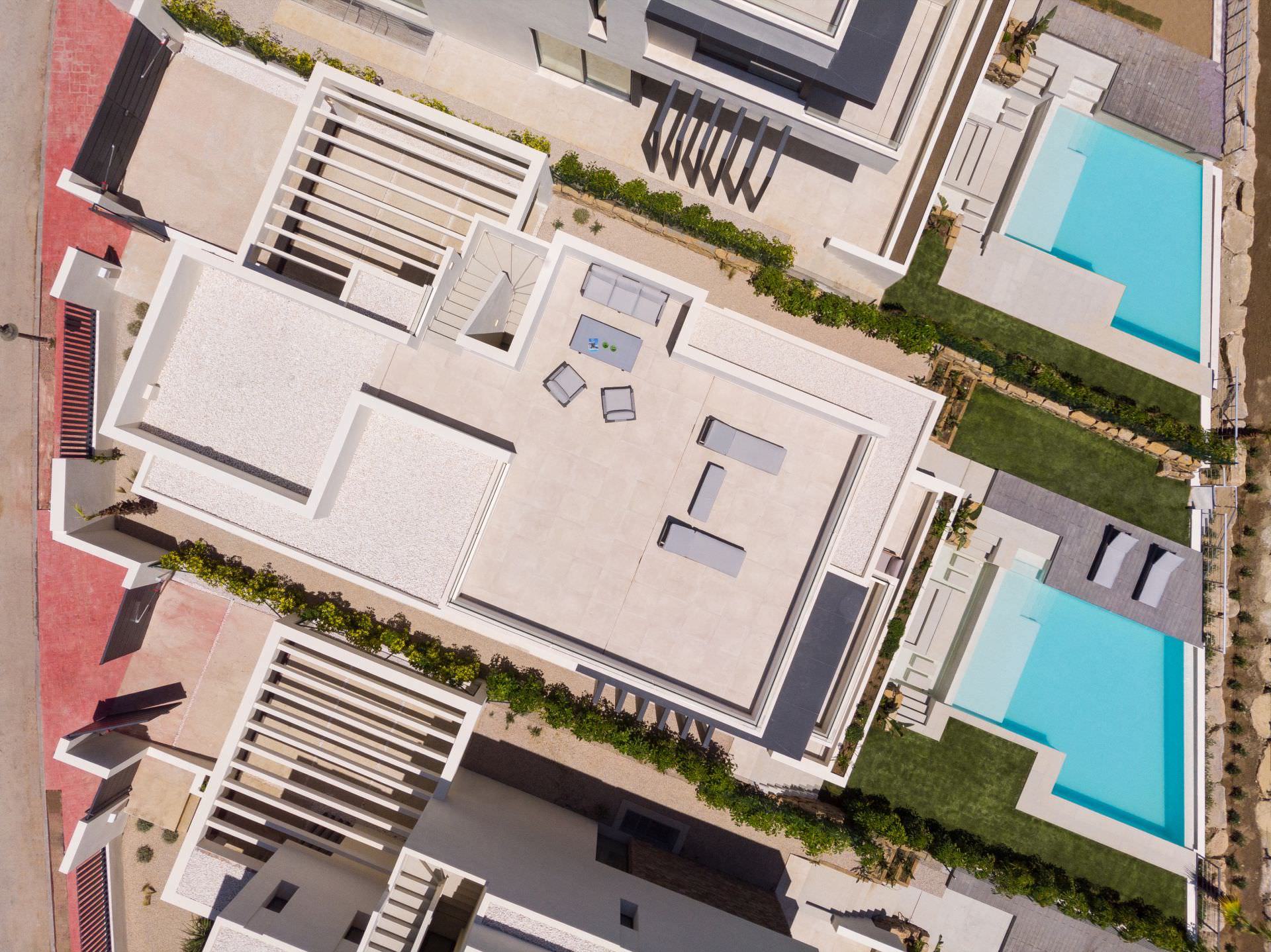Aerial top view of a BELFRY villa showing roofscape, pool geometry and overall plot organization