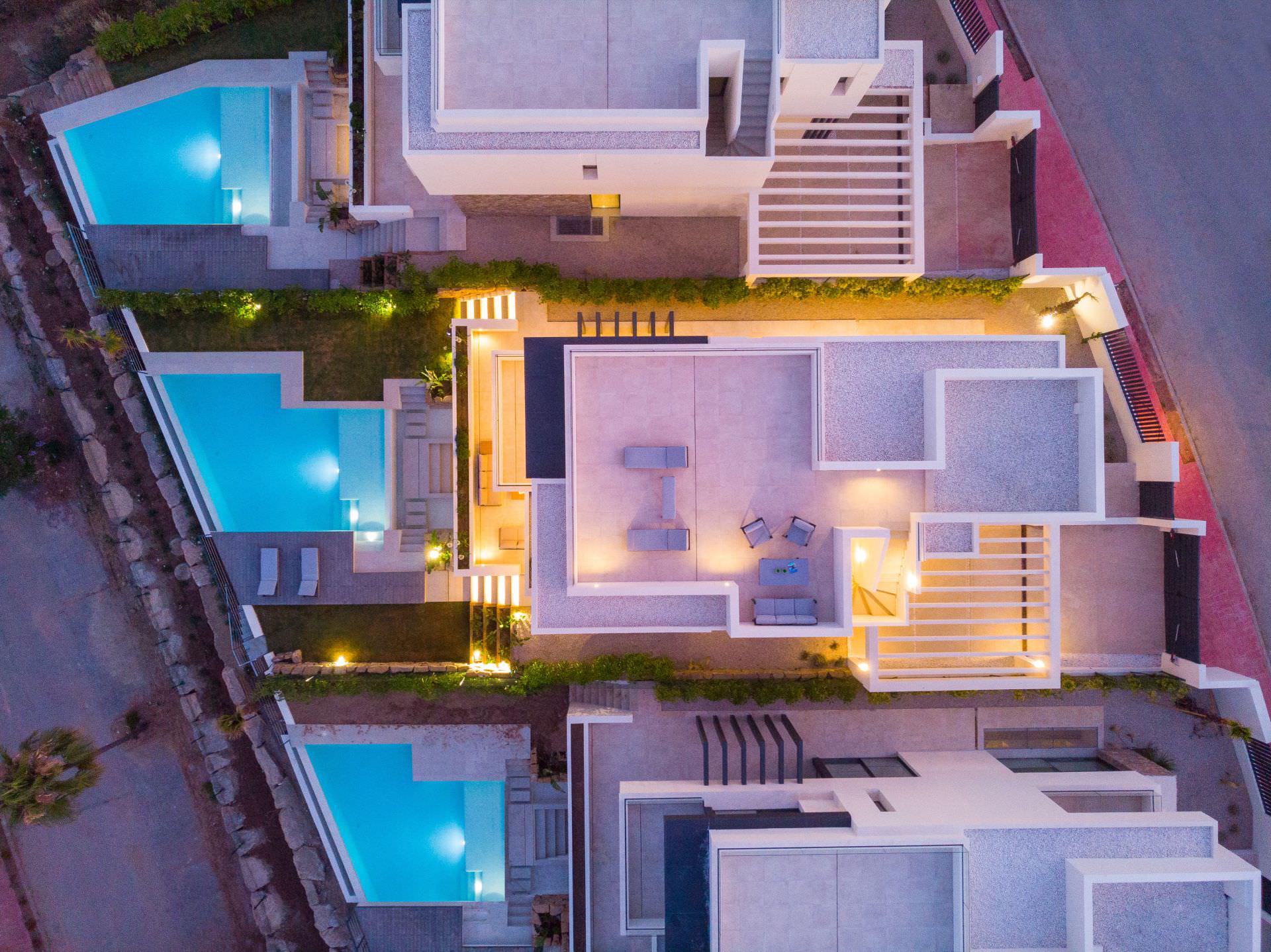 Night aerial top view of a BELFRY villa with illuminated pool, terraces and full site composition