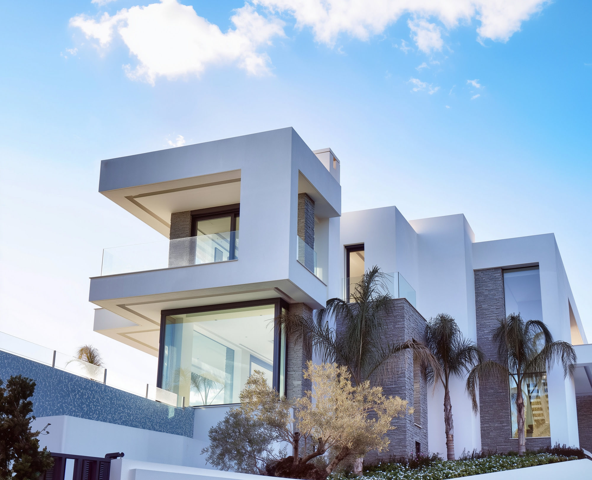 Villa Casalina low angle architectural view highlighting stacked white volumes and Mediterranean sky