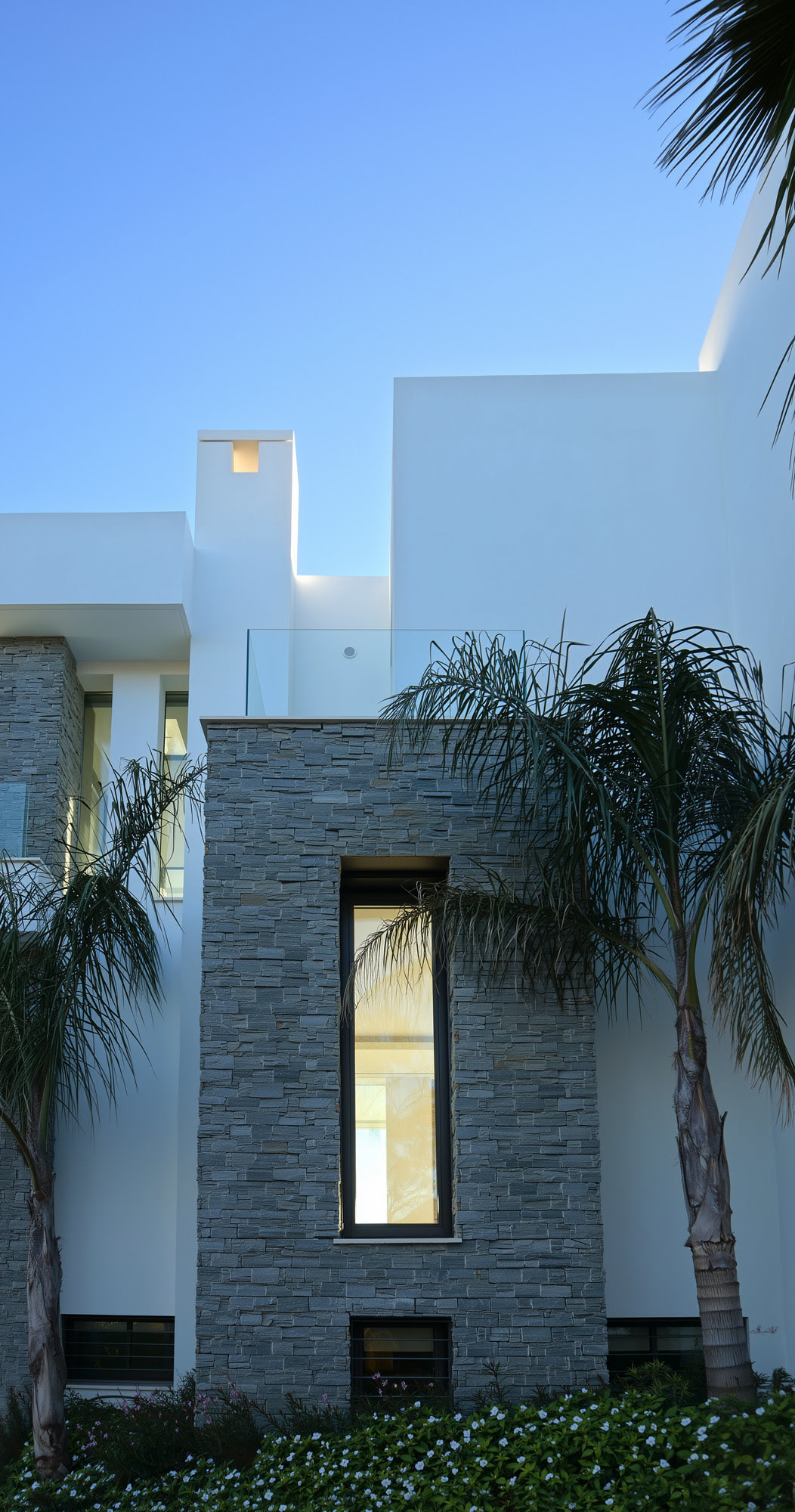 Villa Casalina vertical façade composition combining natural stone, glazing and tropical landscaping