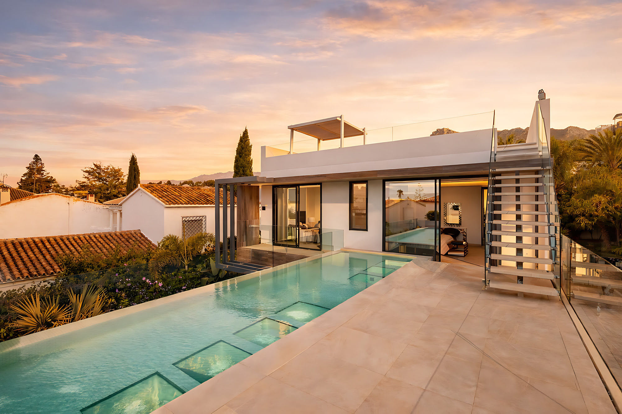 Full exterior view of DALÍ Villa in Marbella with elongated swimming pool, white contemporary volumes and landscaped terrace