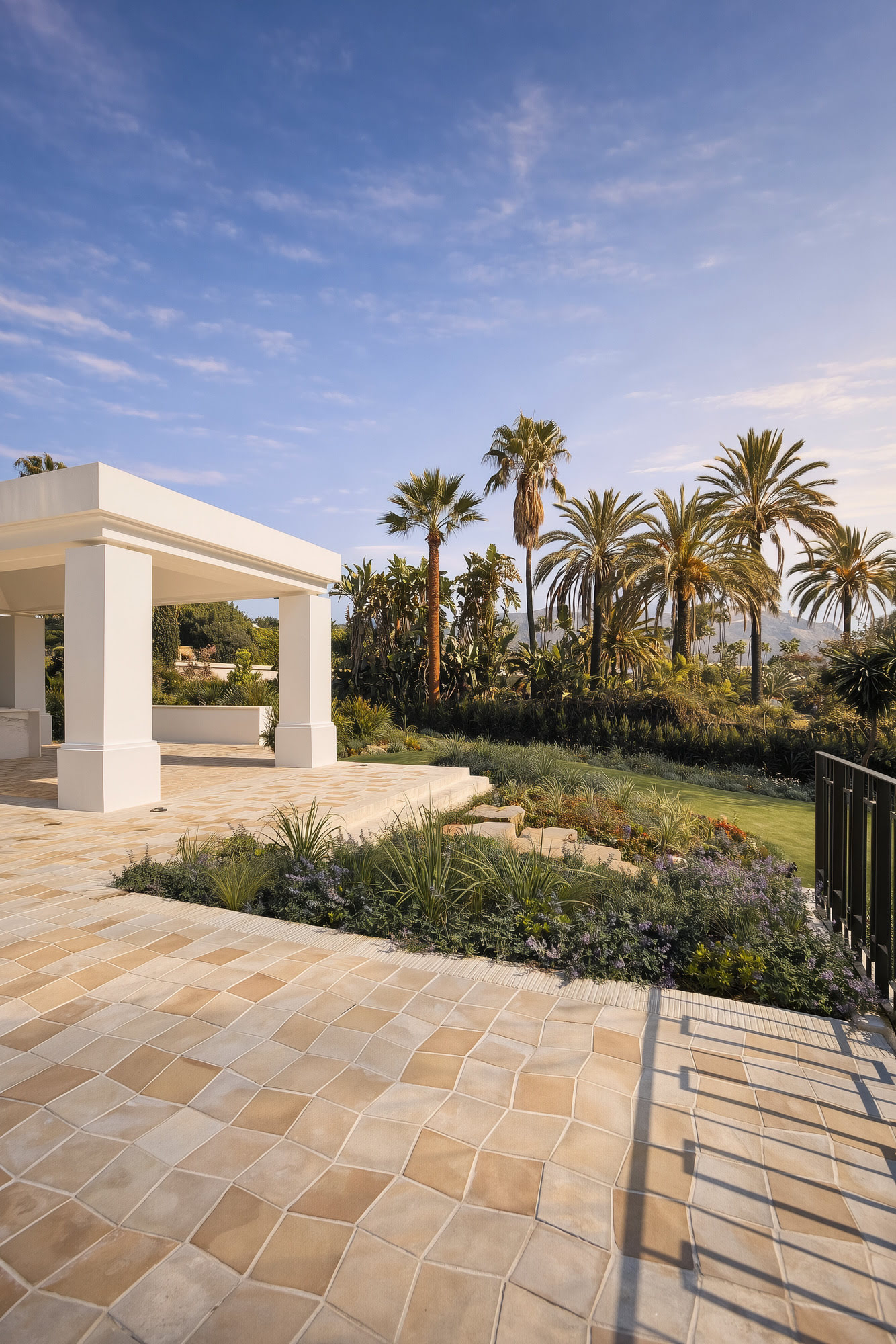 Poolside terrace with pergola, stone paving and open views from Villa Diva in Marbella