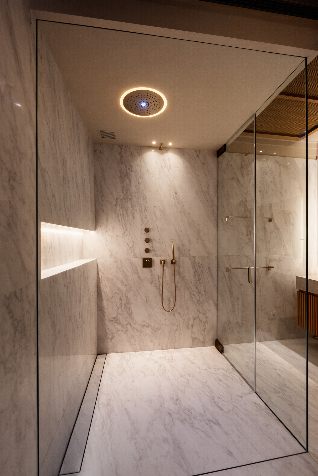 Walk-in marble shower with warm lighting and calm hotel-style atmosphere at Villa Diva