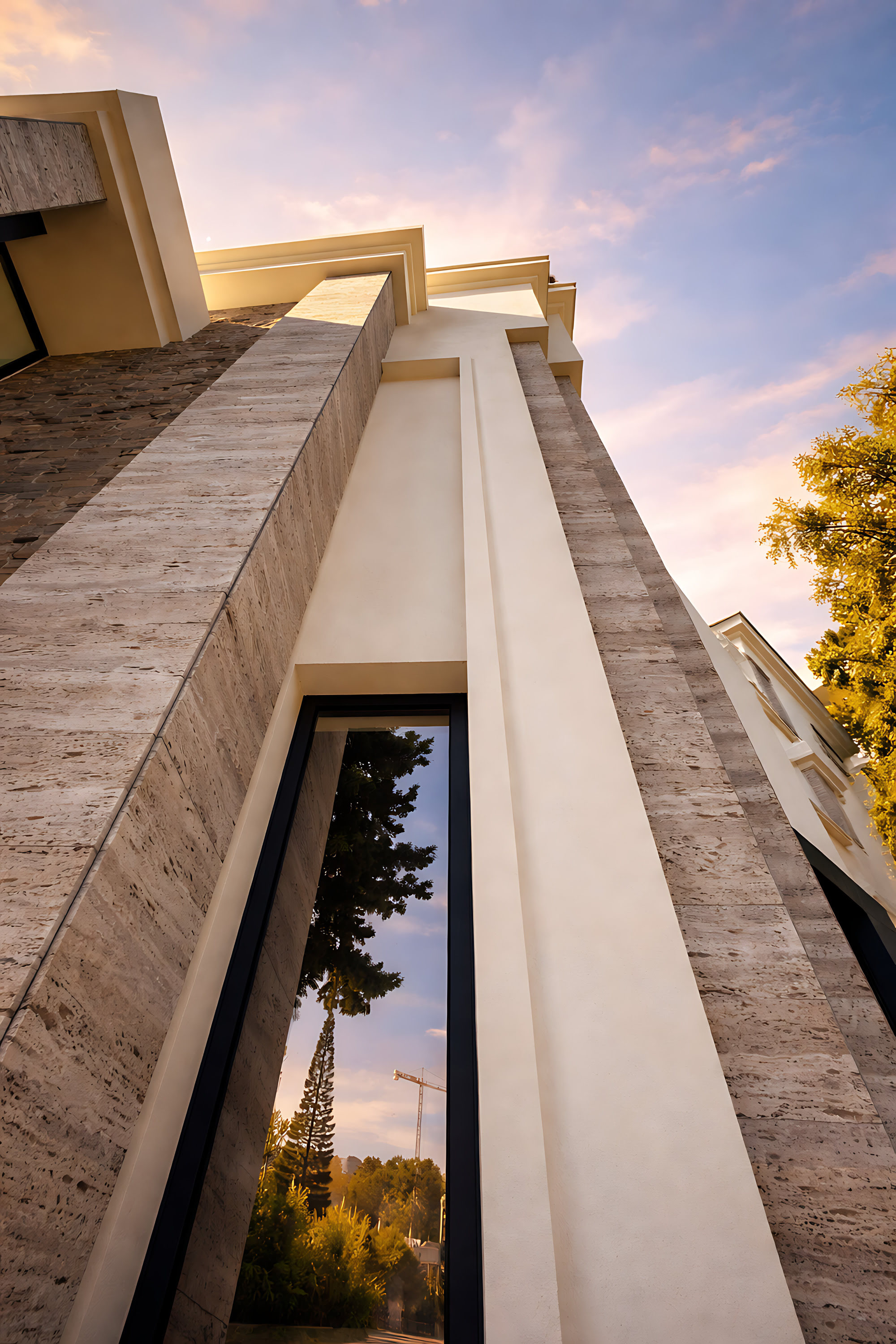 Upward architectural view at Hillview Estate highlighting vertical proportion, stone cladding and slender glazed openings