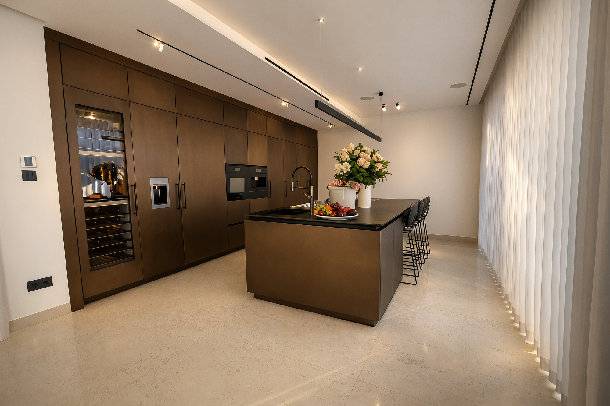 Kitchen at Villa Inés with integrated dark cabinetry, minimalist island and filtered daylight