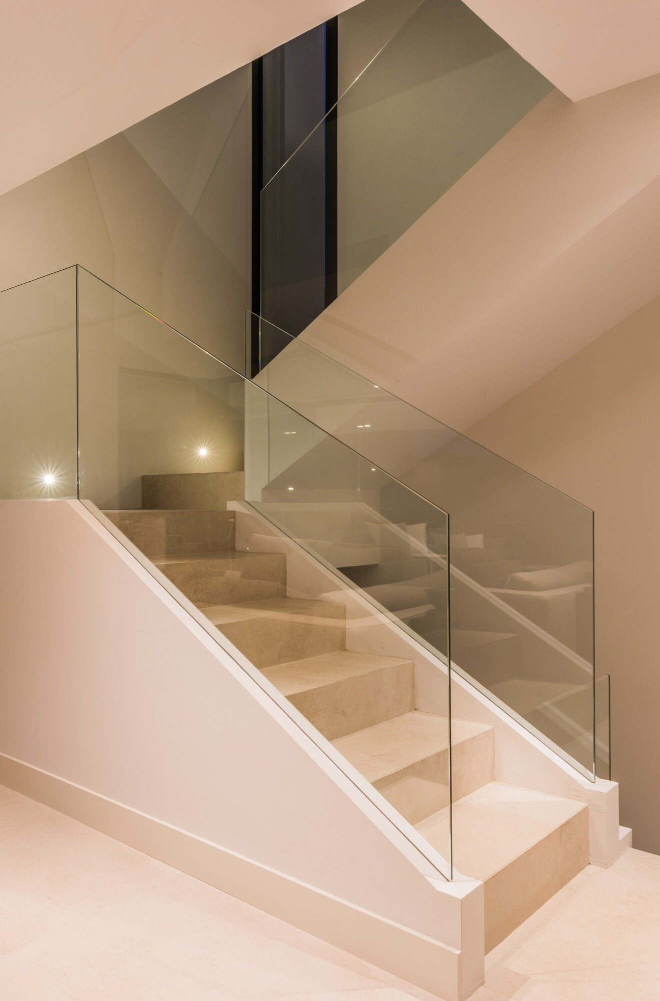 Stair detail at M152 showing glass guardrail, soft lighting and precision architectural detailing