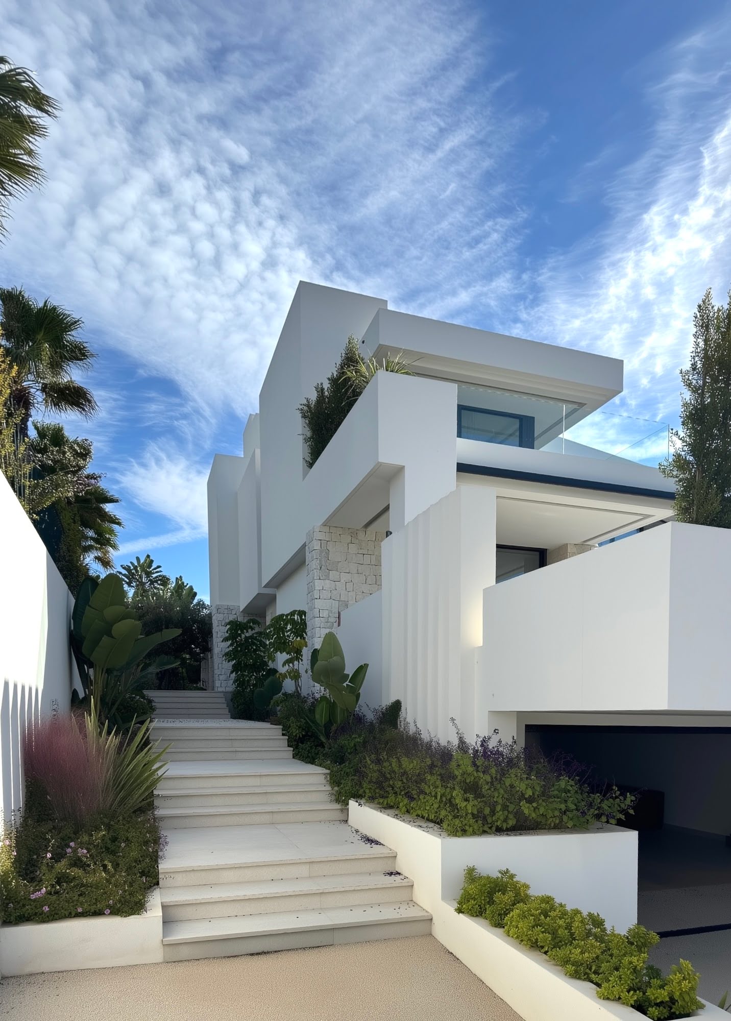 Arrival sequence at M94 with stepped landscape approach and sculptural white villa volumes