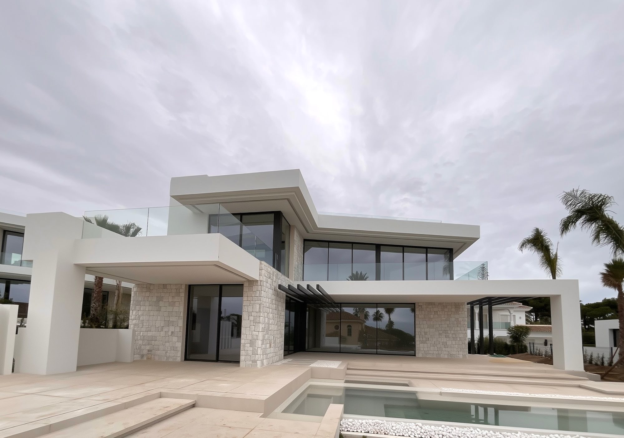 Front elevation of an M94 villa in Marbella East with strong horizontal lines, white render and open terrace