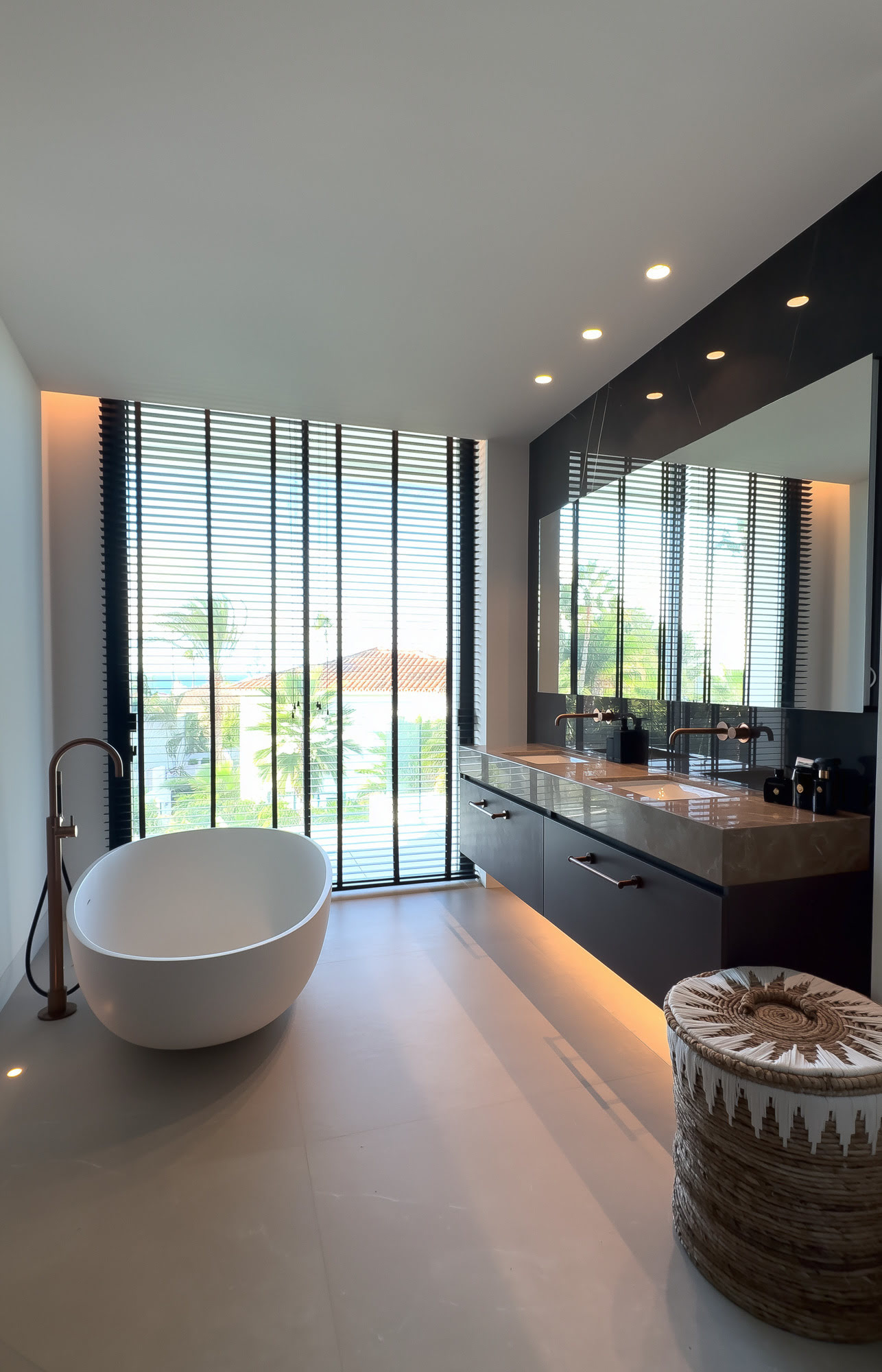 Spa style bathroom at M94 with freestanding tub, dark finishes and filtered light from the garden