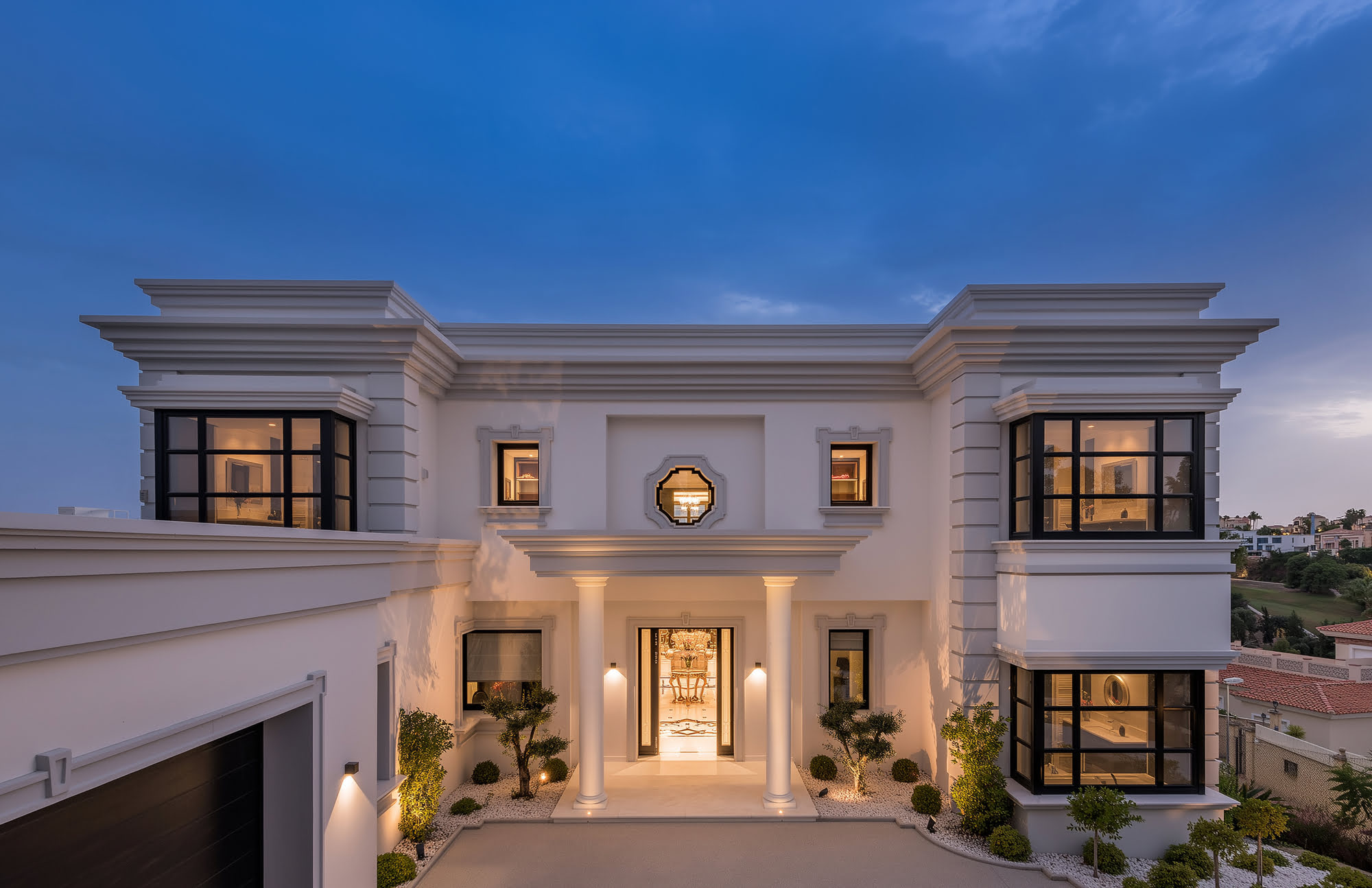 Twilight front elevation of Villa Mariselena with grand classical symmetry and warm architectural lighting