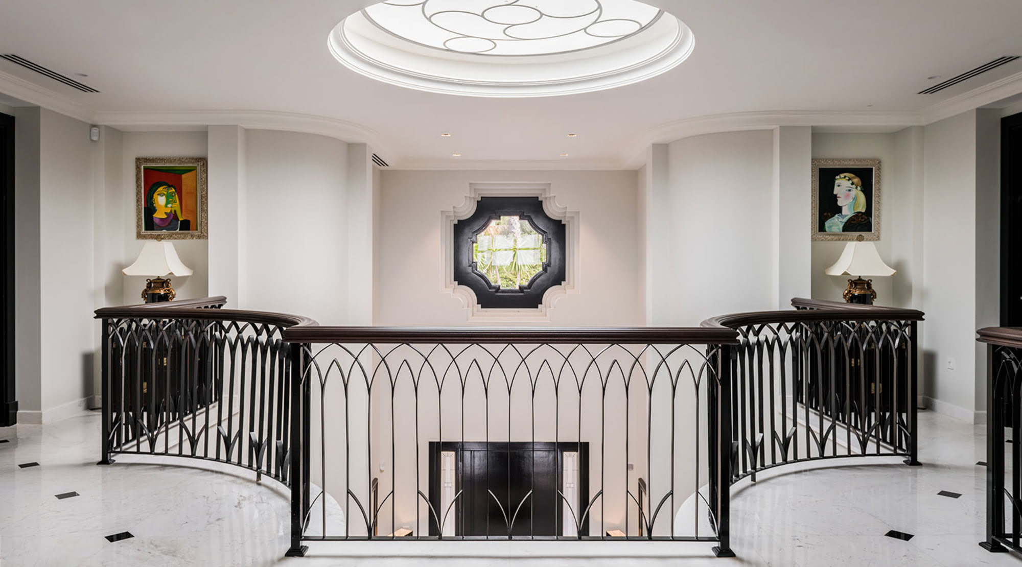 Upper hall of Villa Mariselena with classical fireplace, oval skylight and wrought iron balustrades