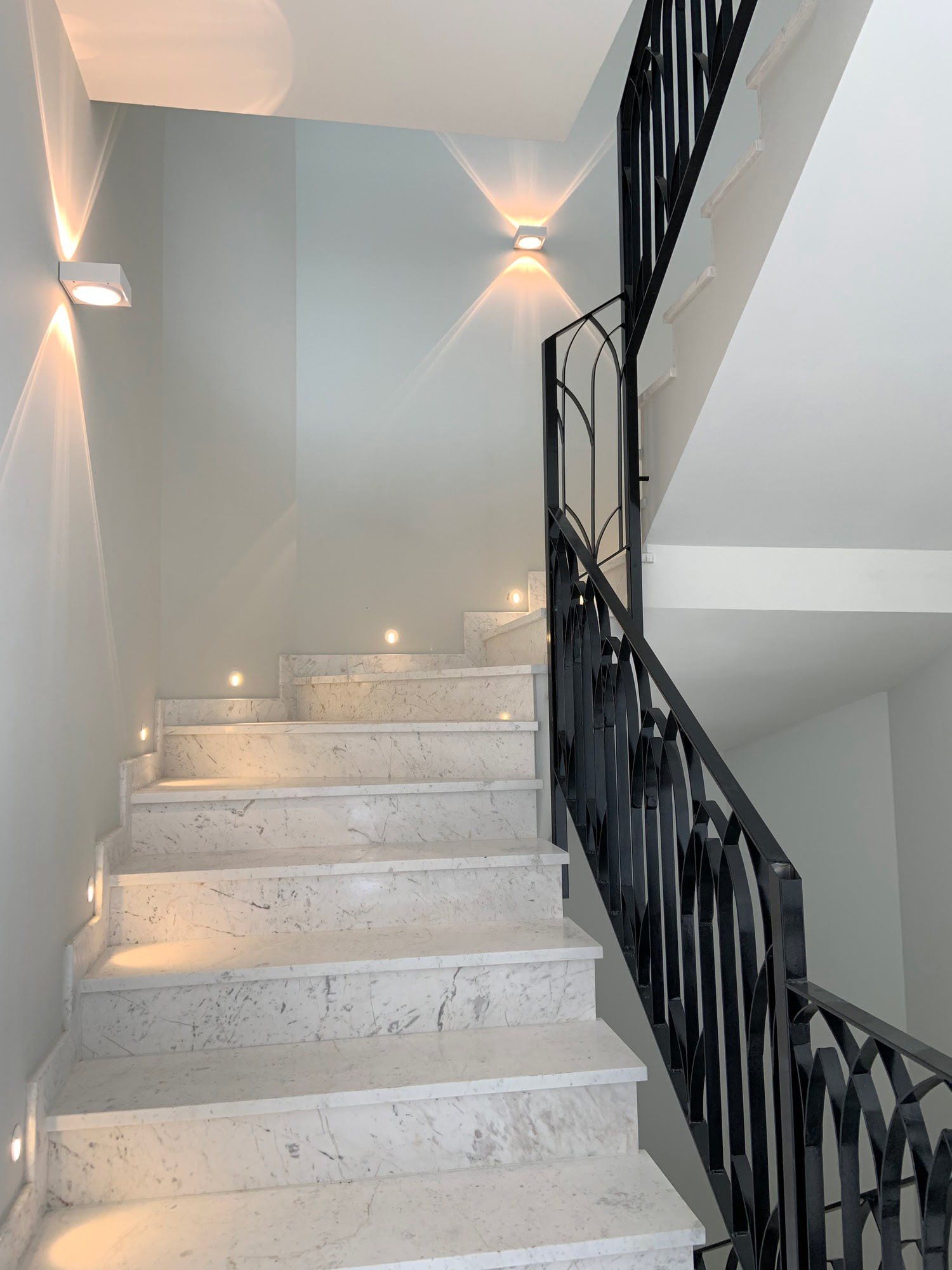Marble staircase with wrought iron handrail inside Villa Mariselena, expressing classical interior detailing
