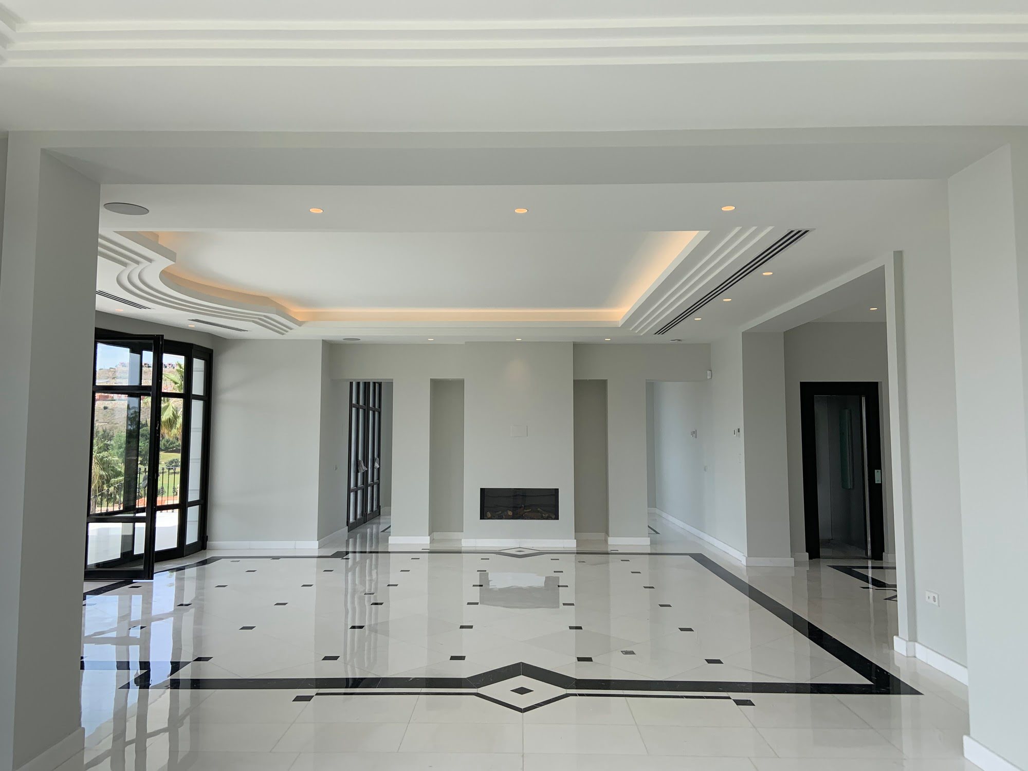 Formal living room of Villa Mariselena with marble flooring, recessed ceiling lighting and elegant classical proportions