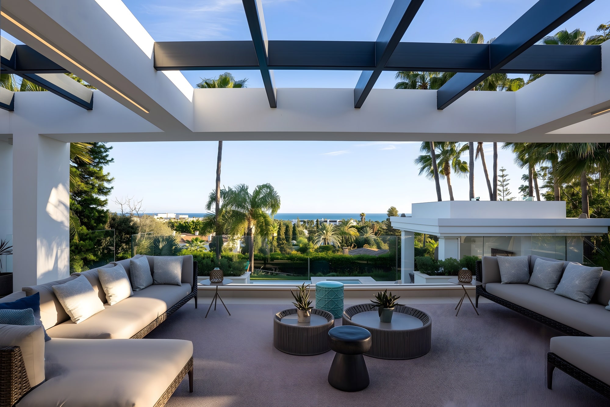 Covered exterior lounge with pergola, shaded seating and sea-facing Mediterranean ambience