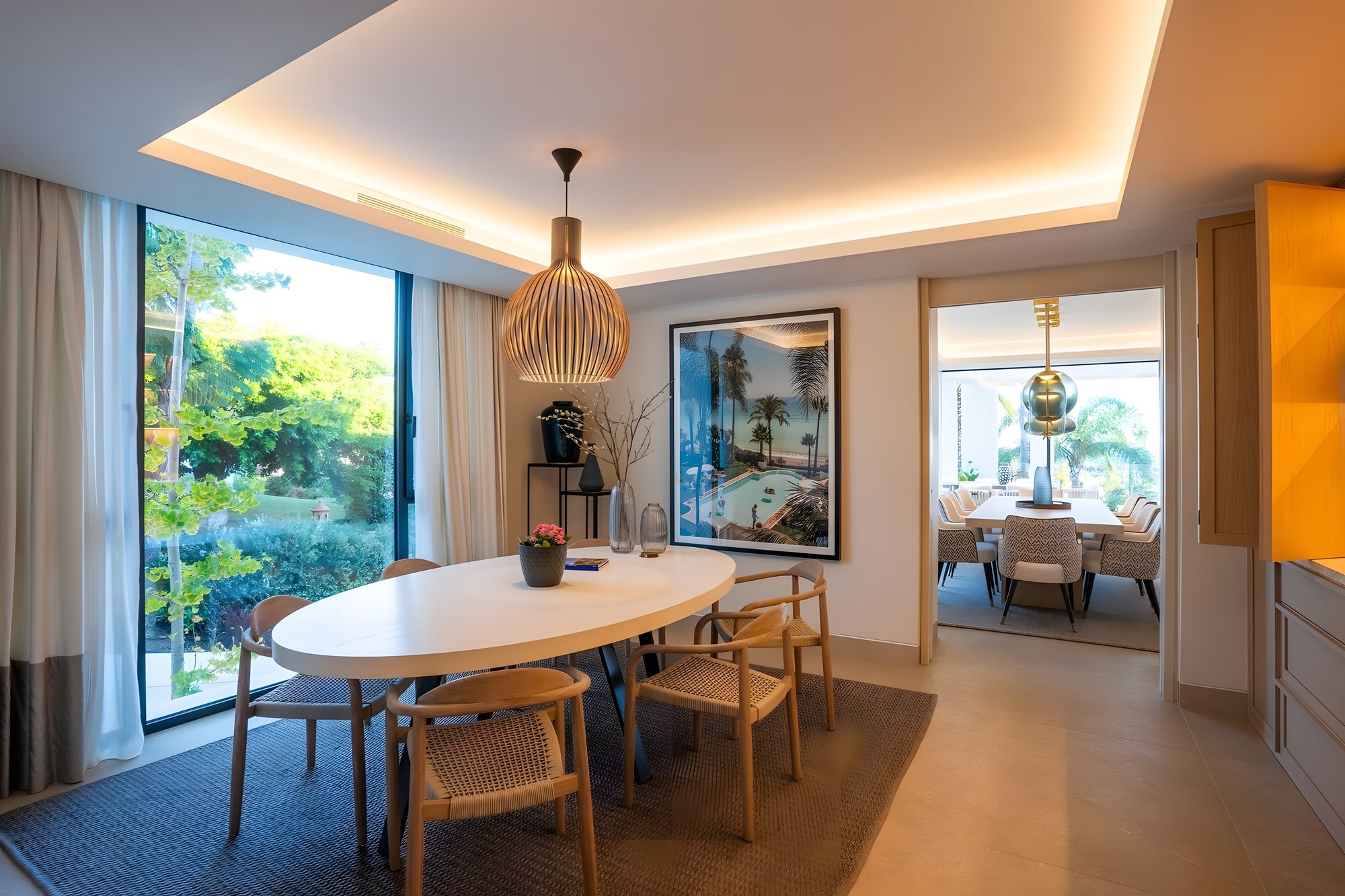 Dining room with framed garden views and warm natural finishes inside Casa de las Palmeras