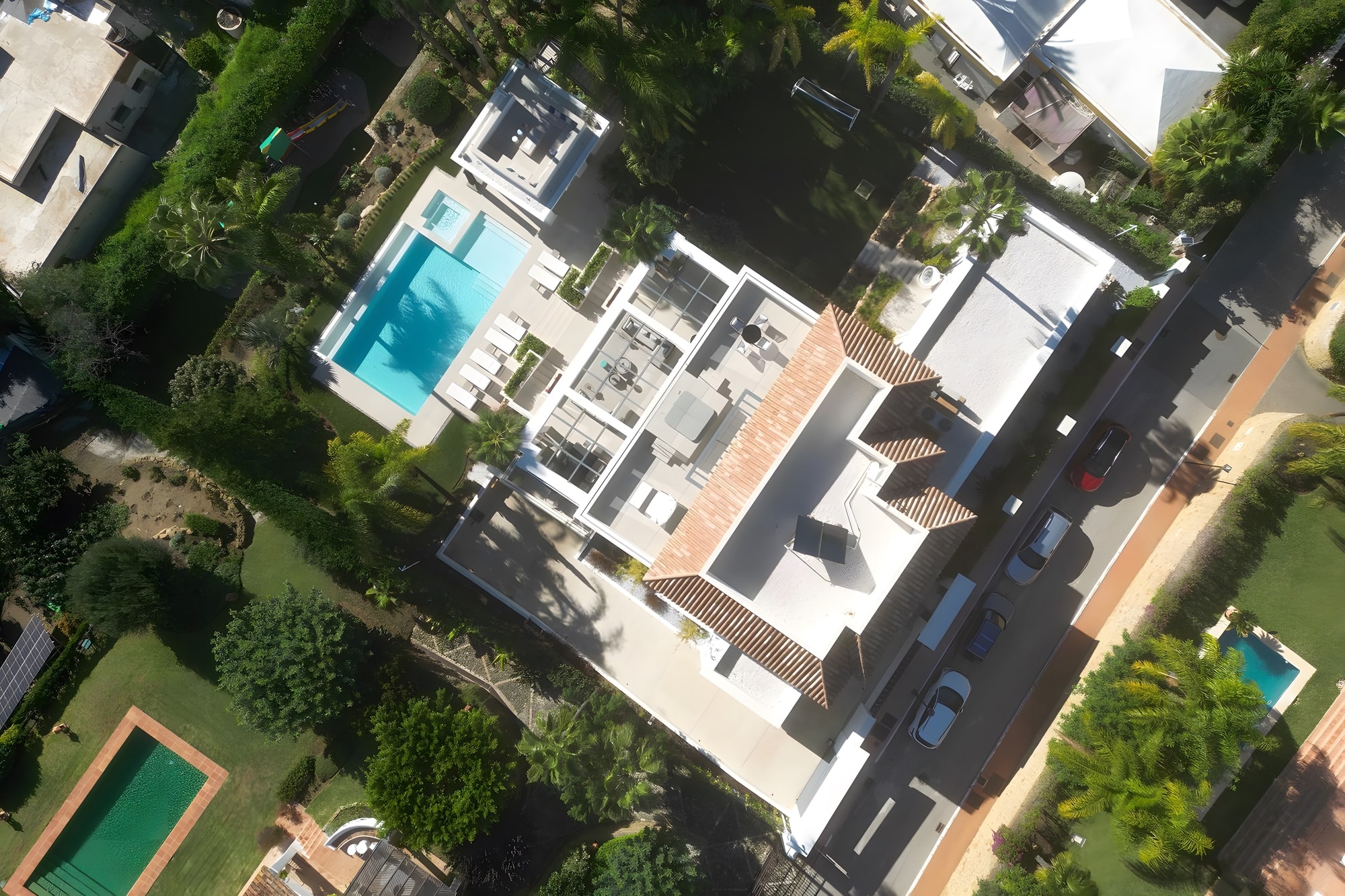 Aerial view of Casa de las Palmeras in Estepona showing the villa, pool terraces, tropical garden and surrounding Costa del Sol setting