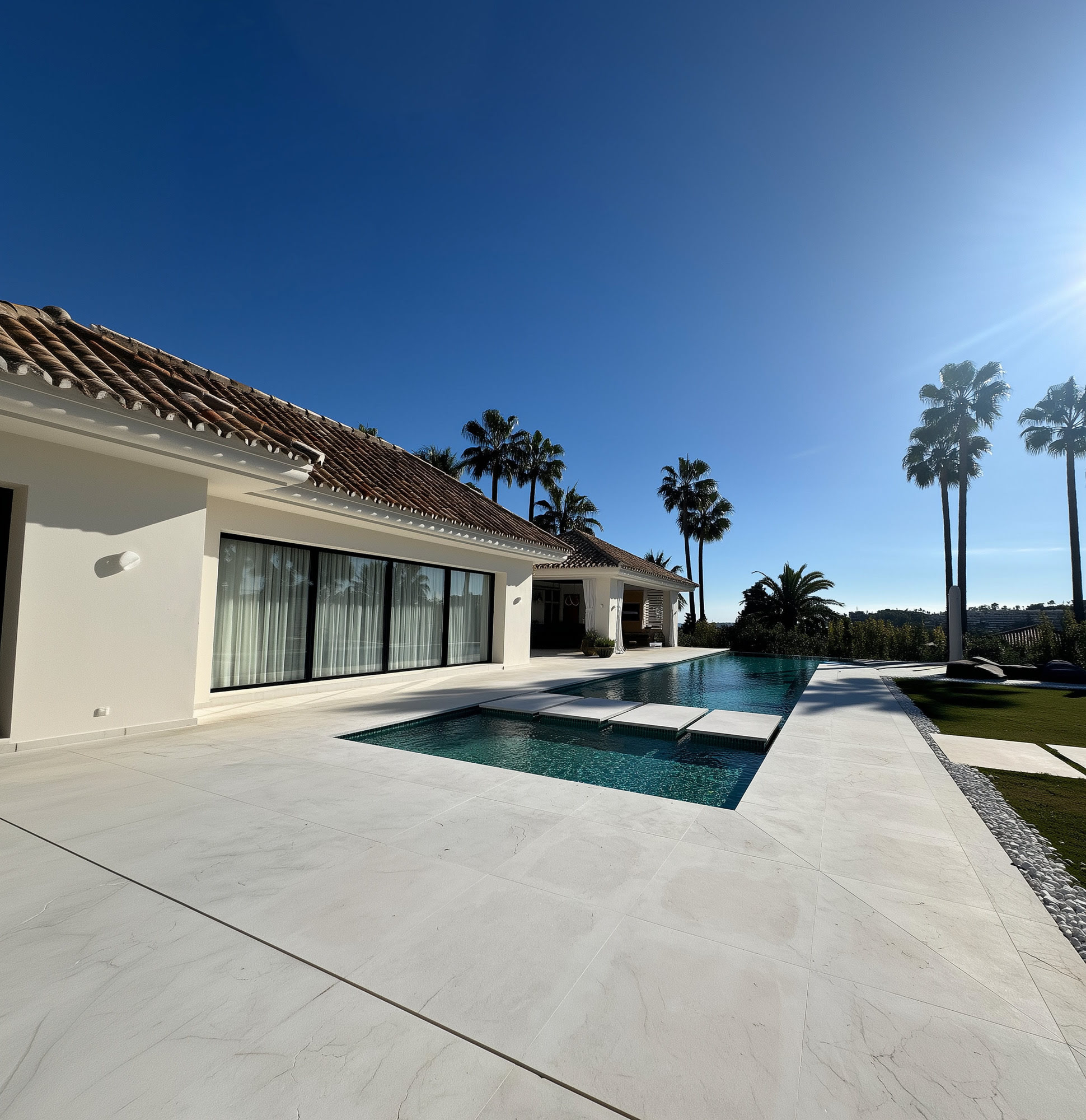 Pool edge and paved terrace framing the main living wing of Villa Shangri-La in Marbella