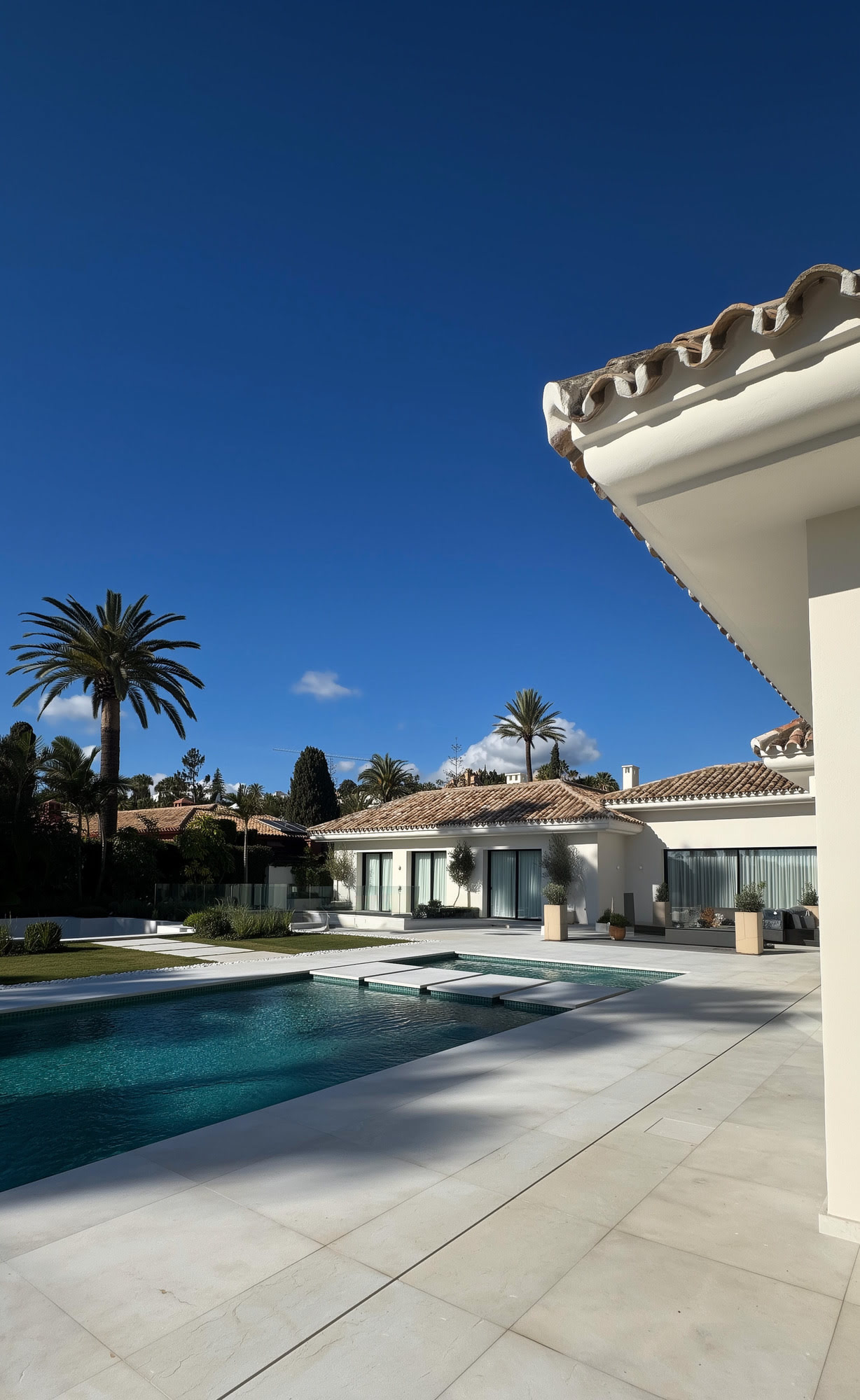 Side perspective of Villa Shangri-La showing the swimming pool, pale façades and tiled Mediterranean roof