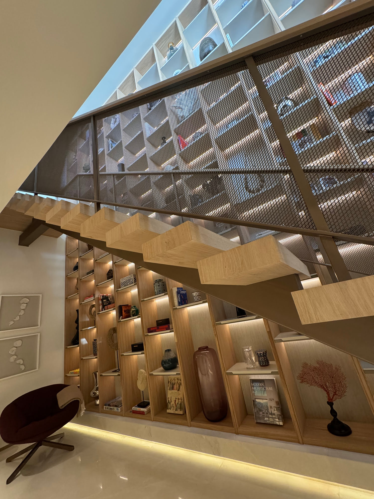 Double height entrance hall and feature staircase with illuminated display wall at Villa Shangri-La
