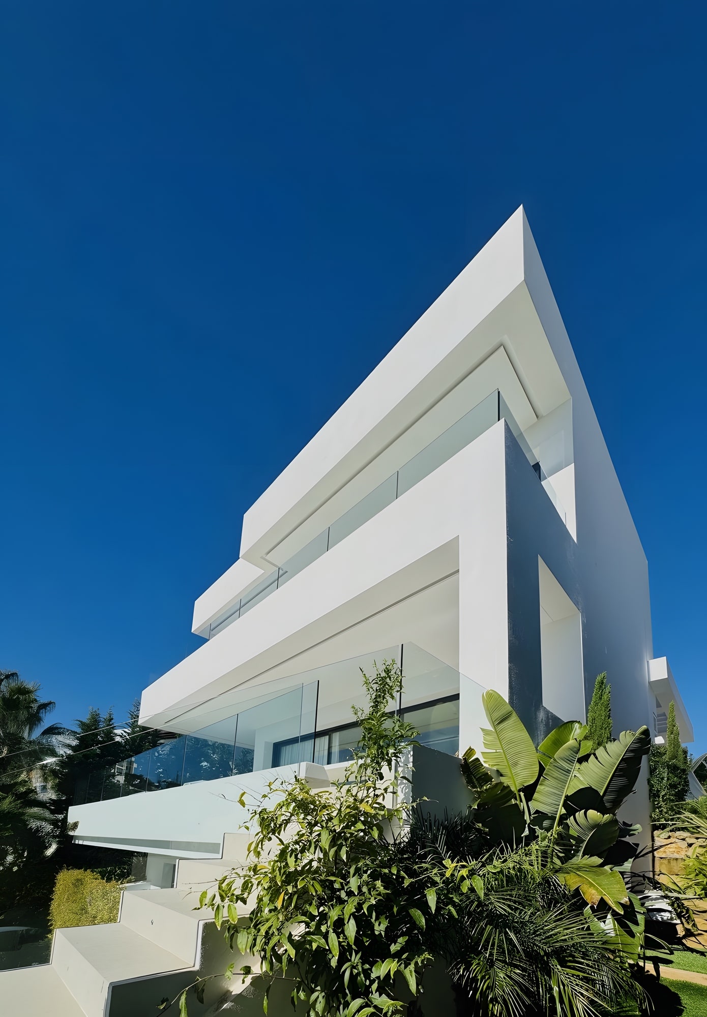 Upward exterior view highlighting the sharp overhangs and architectural composition against the blue sky