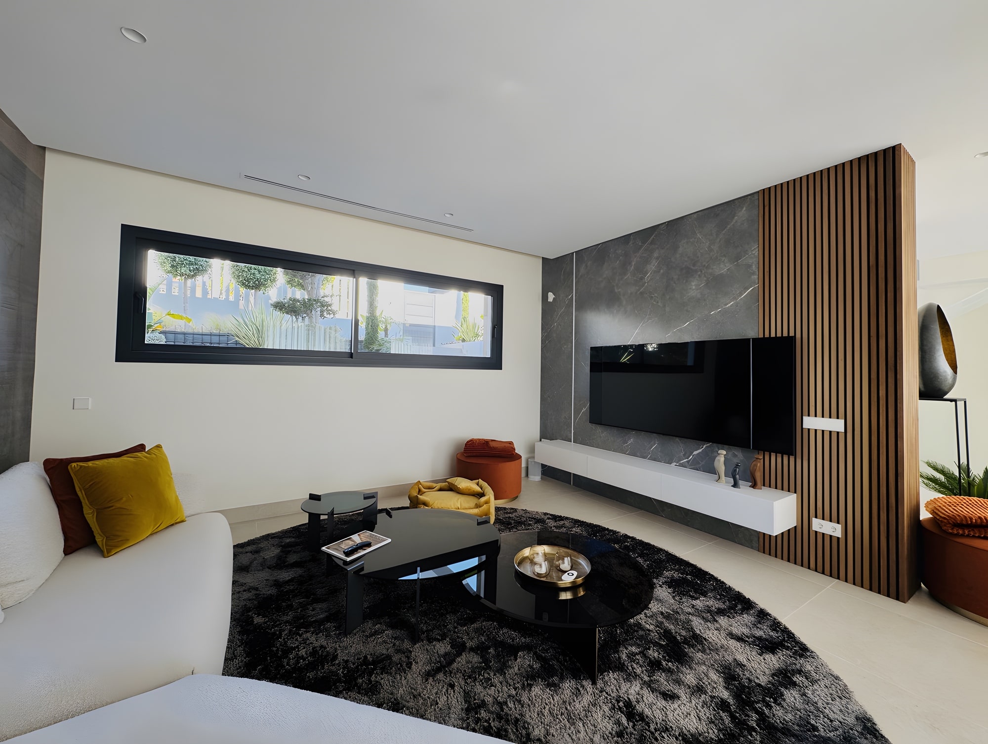 Contemporary lounge with fireplace wall, textured rug and warm timber detailing