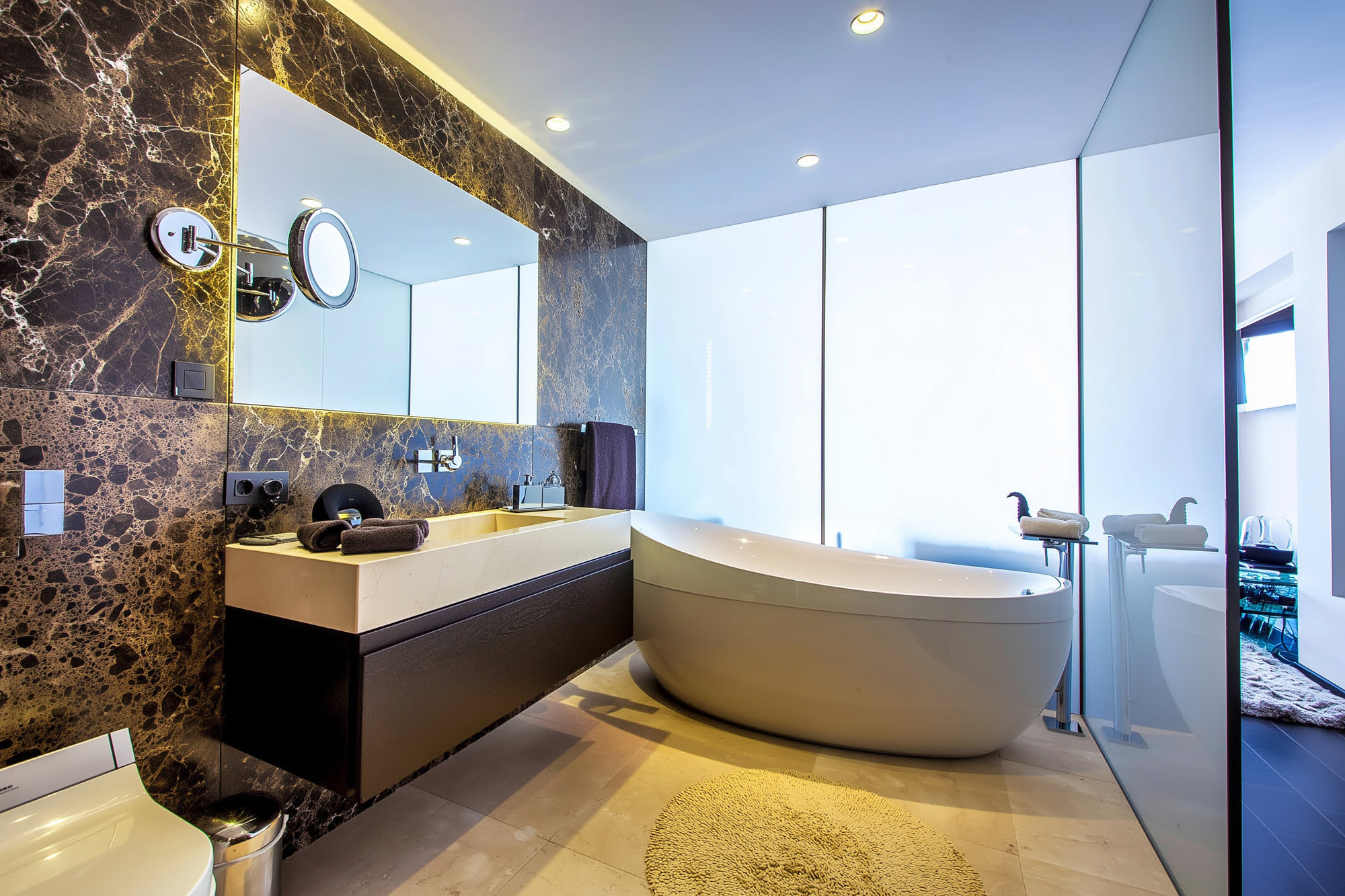 Luxury bathroom interior at Villa Tanya with marble vanity, sculptural bathtub and warm natural light