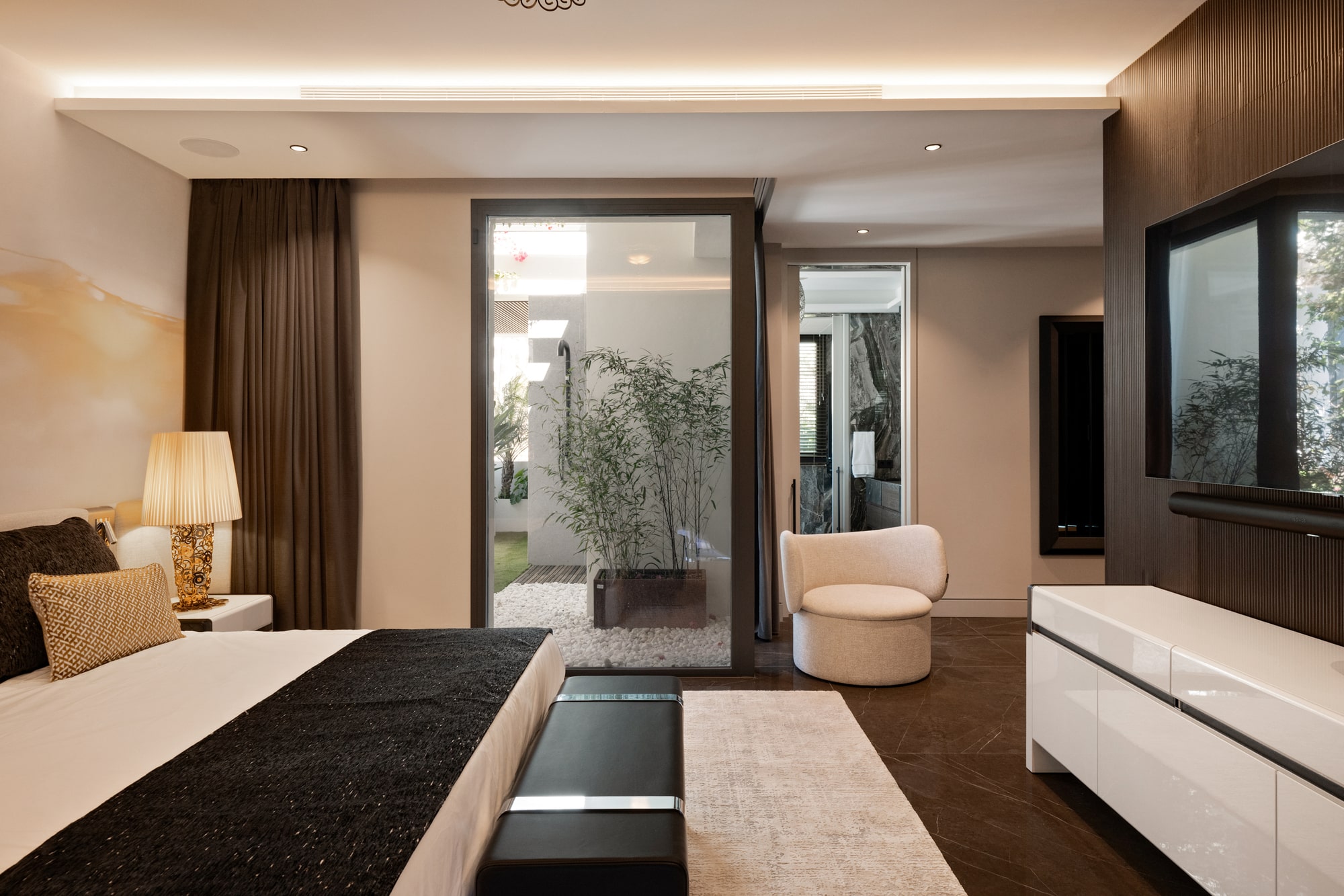 Bedroom suite at Casa Velázquez with warm timber wall treatment, private seating and terrace access
