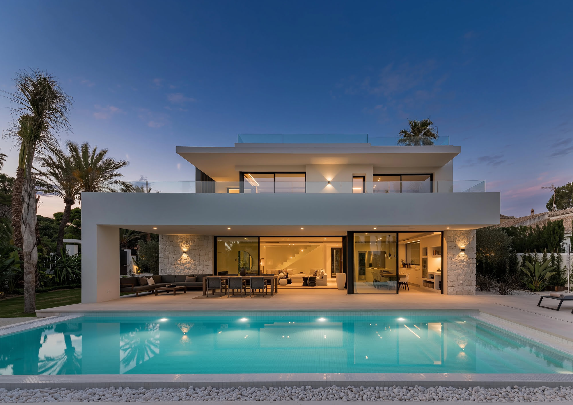 Frontal dusk view of VIDA DEL MAR in Marbella East with symmetrical façade, pool reflections and soft interior glow