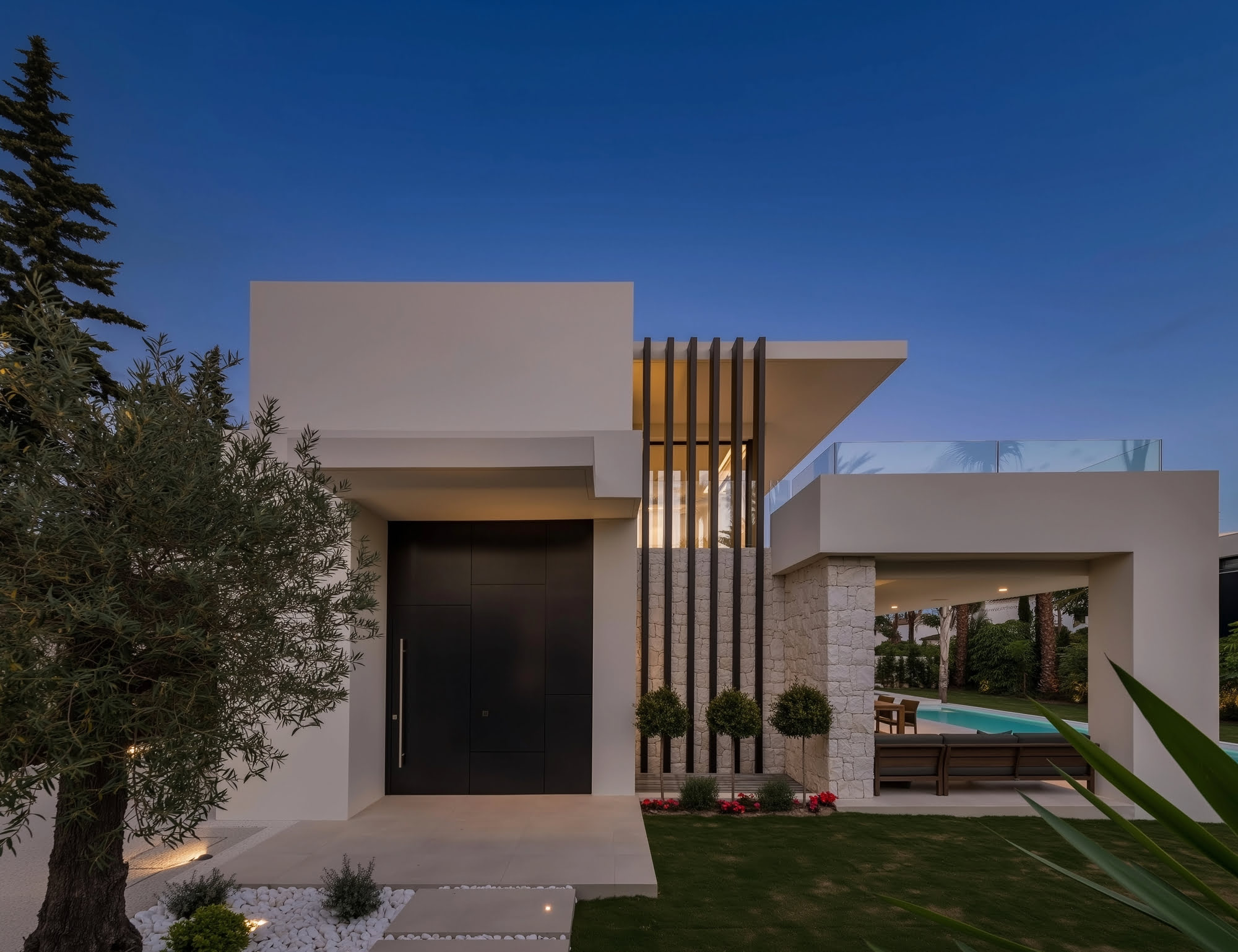 Twilight entrance view of VIDA DEL MAR with illuminated facade, stone textures and calm symmetry