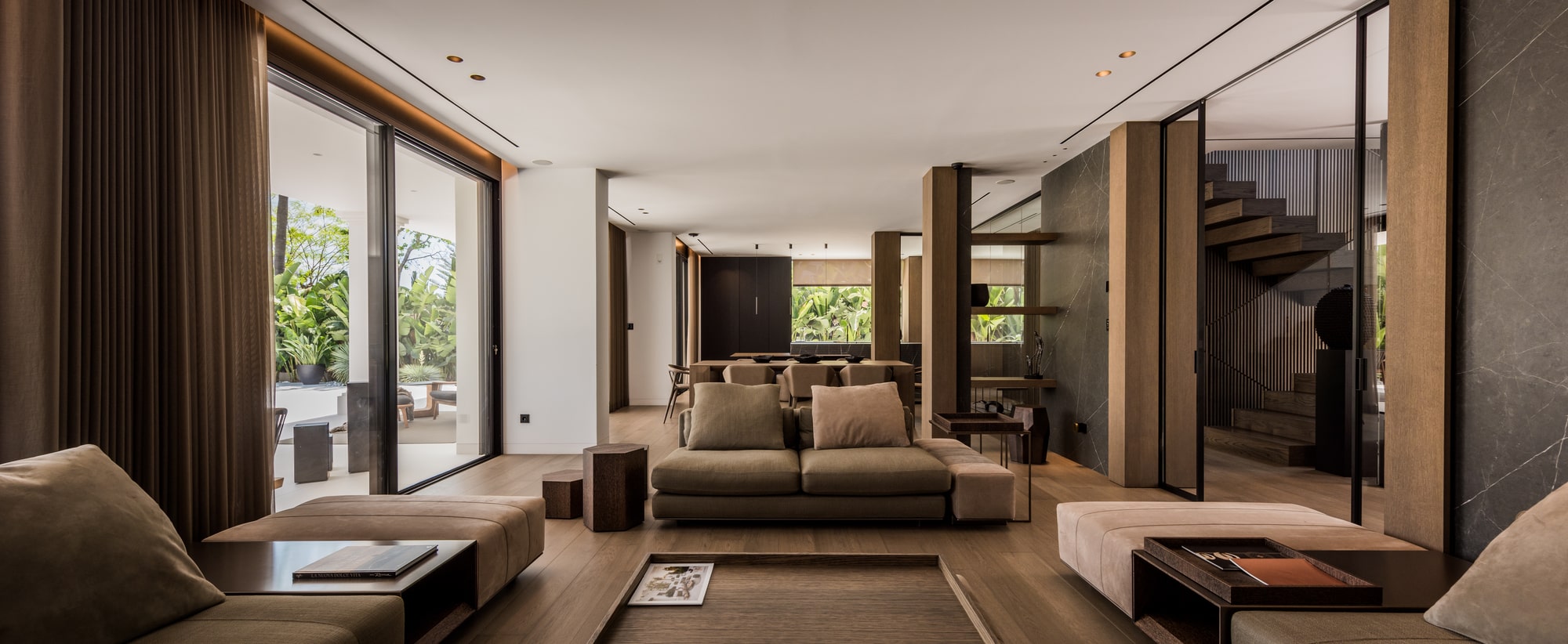 Main living room at Villa Zarina with layered seating, warm timber finishes, integrated lighting and strong connection to the garden