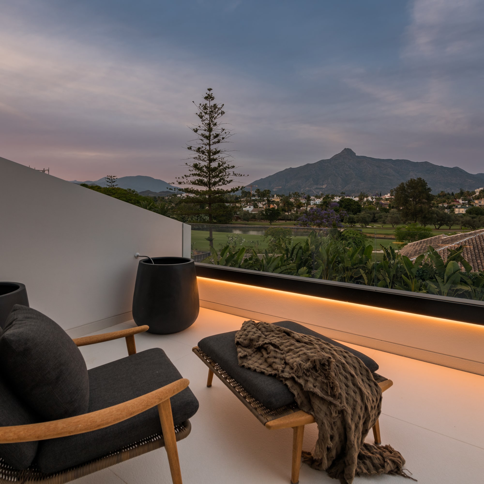 Private terrace at Villa Zarina with sunset sky, mountain views and outdoor seating overlooking the Marbella landscape